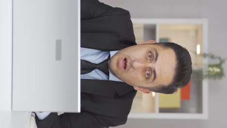 Vertical-video-of-Home-office-worker-man-looking-at-camera-confused.
